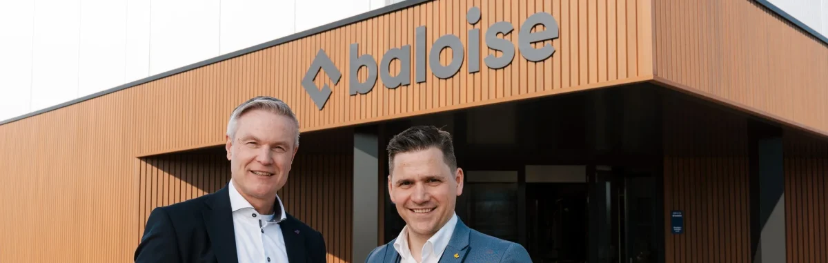 Foto met Arend-Jan Koorn, General Manager Baloise Nederland en Manu Mus, Director Distribution Partnerships Baloise België poserend voor het pand van Baloise in Beesd.
